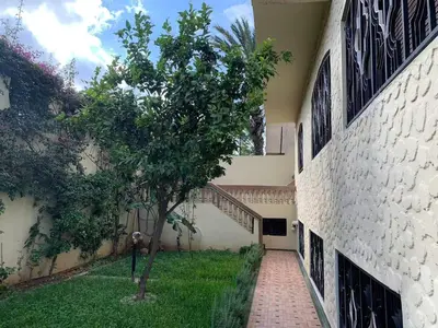 a tree in front of a building with a walkway at Grand Andalusian Villa Private Garage and Garden in Casablanca