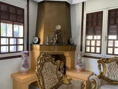 a living room with two chairs and a fireplace at Grand Andalusian Villa Private Garage and Garden in Casablanca