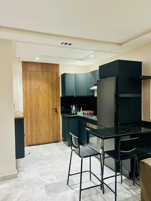 a kitchen with black cabinets and a table and chairs at Located at Building 55, Golden Pavilion, 3rd Floor in Casablanca