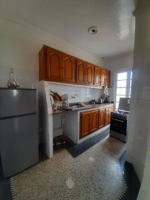 a kitchen with wooden cabinets and a stainless steel refrigerator at Cozy Studio with Balcony, Casa Center Close to Everything in Casablanca