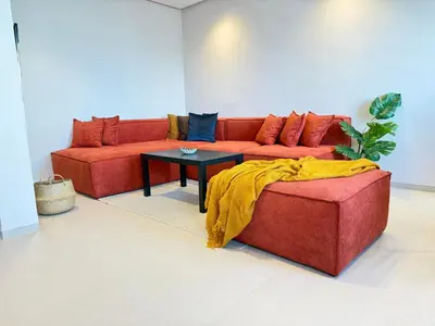 a red couch in a living room with a table at Appartement moderne et chaleureux au cœur de Rabat in Rabat