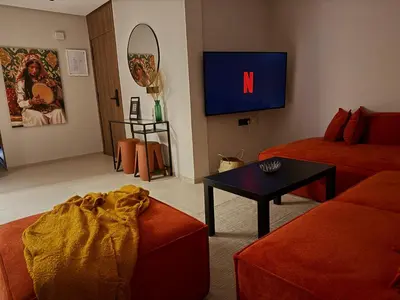 a living room with a couch and a tv at Appartement moderne et chaleureux au cœur de Rabat in Rabat