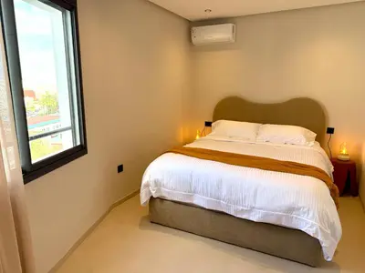 a bedroom with a large bed and a window at Appartement moderne et chaleureux au cœur de Rabat in Rabat