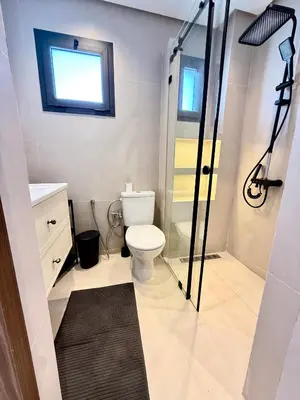 a bathroom with a toilet and a glass shower at Appartement moderne et chaleureux au cœur de Rabat in Rabat