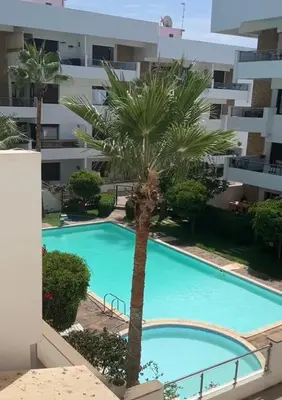 a palm tree in front of a building at Charming 3 bedroom with pool in the building in Casablanca