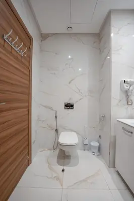 a white bathroom with a toilet and a sink at L'Amber 1 chambre - 5 min de l'Aéroport- Piscine in Nouaseur