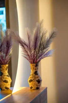 two vases with feathers on top of a table at L'Amber 1 chambre - 5 min de l'Aéroport- Piscine in Nouaseur