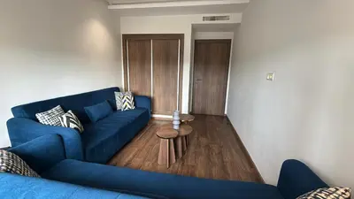 a living room with a blue couch and a table at Appartement Résidence Tamaris Park in Tamaris