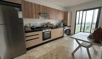 a kitchen with a stainless steel refrigerator and a table at Appartement Résidence Tamaris Park in Tamaris
