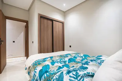 a bedroom with a bed with a blue and white blanket at Luxury Residence Beach Gym and Garage in Pont Blondin