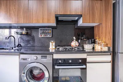 a kitchen with a washing machine and a stove at Luxury Residence Beach Gym and Garage in Pont Blondin