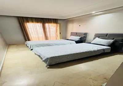a bedroom with two beds and a large window at Familly Residence in Casablanca