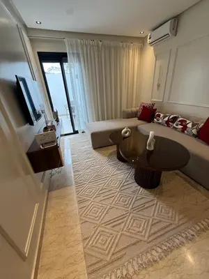 a living room with a couch and a tv at Suite Apartment Maarif Val Fleurie à louer in Casablanca
