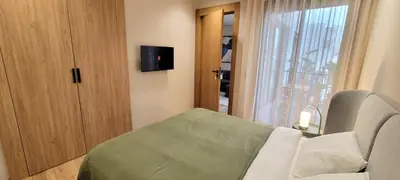 a bedroom with a bed and a tv on the wall at Appartement moderne avec parking, toit terrasse et salle de sport - Anfa Park in Casablanca