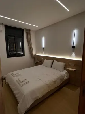 a bedroom with a large bed with lights on it at Central T1 cozy and chic in Rabat