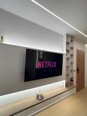 a television on a wall in a living room at Central T1 cozy and chic in Rabat