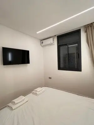 a bedroom with a bed with a tv and a window at Central T1 cozy and chic in Rabat