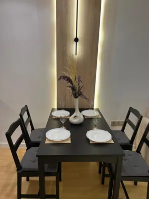 a black table with four chairs and a vase on it at Central T1 cozy and chic in Rabat