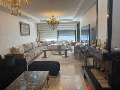 a living room with a couch and a table at Jolie appartement avec piscine privée in Casablanca