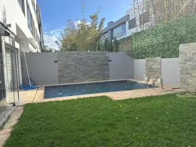 a swimming pool in a yard next to a building at Jolie appartement avec piscine privée in Casablanca