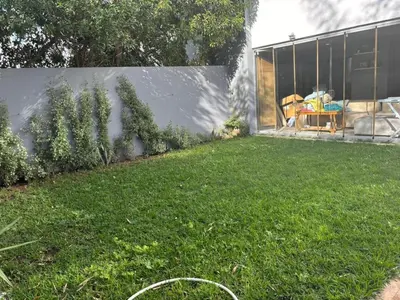 a backyard with a lawn and a building at Jolie appartement avec piscine privée in Casablanca