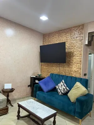 a living room with a blue couch and a tv at Cozy Apartment Rabat in Rabat
