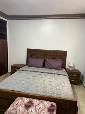 a bedroom with a large bed with purple pillows at Cozy Apartment Rabat in Rabat