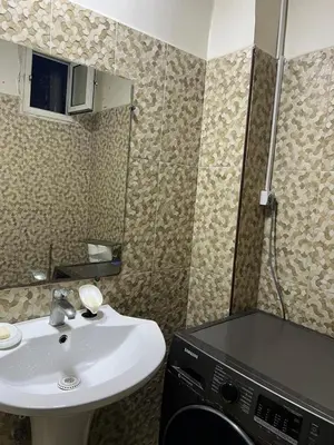 a bathroom with a sink and a washing machine at Cozy Apartment Rabat in Rabat