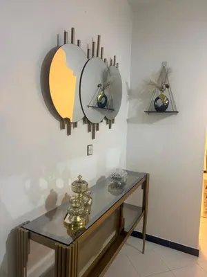 a glass table with two mirrors on a wall at Nouvel appartement dans le quartier central très agréable à proximité de tous les services in Temara