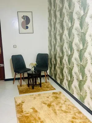 two chairs and a table in a room at Nouvel appartement dans le quartier central très agréable à proximité de tous les services in Temara