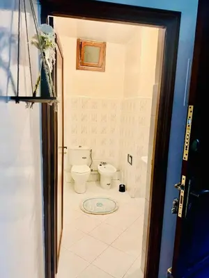 a bathroom with a toilet and a door open at Nouvel appartement dans le quartier central très agréable à proximité de tous les services in Temara