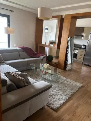 a living room with a couch and a glass table at Appartement lumineux avec parking privé in Temara