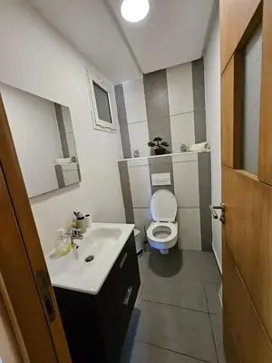 a small bathroom with a toilet and a sink at Appartement lumineux avec parking privé in Temara