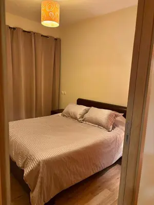 a bedroom with a bed and a lamp and a bed at Appartement lumineux avec parking privé in Temara