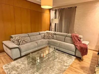 a living room with a couch and a glass table at Appartement lumineux avec parking privé in Temara