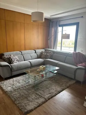a living room with a couch and a glass table at Appartement lumineux avec parking privé in Temara