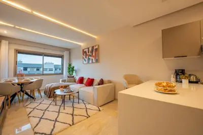 a living room with a couch and a table at Le Rubis - Appartement pour 3 personnes - Avec Piscine - Proche aeroport Mohammed 5 in Nouaseur