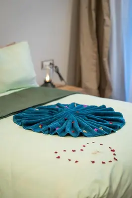 a blue blanket on top of a bed with confetti at Le Rubis - Appartement pour 3 personnes - Avec Piscine - Proche aeroport Mohammed 5 in Nouaseur