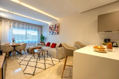 a living room with a couch and a table at Le Rubis - Appartement pour 3 personnes - Avec Piscine - Proche aeroport Mohammed 5 in Nouaseur