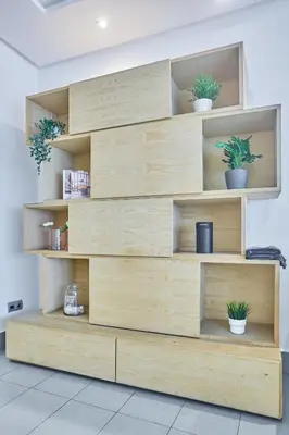 a wooden book shelf with potted plants on it at Chic 3BR in Racine by Bd Massira in Casablanca
