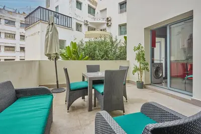 a patio with a table and chairs on a balcony at Chic 3BR in Racine by Bd Massira in Casablanca