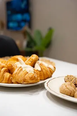a plate of croissants and other pastries on a table at Soleya Apartment with Pool near Mohammed V Airport in Nouaseur