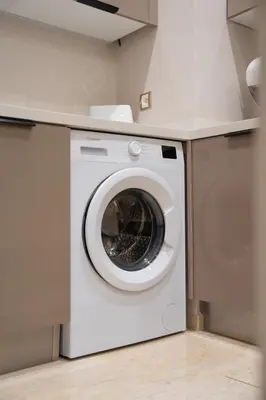 a white washing machine sitting in a kitchen at Soleya Apartment with Pool near Mohammed V Airport in Nouaseur