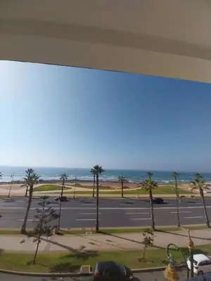 a view of a parking lot with palm trees and the ocean at Appartement vue sur mer - Chill ocean view in Rabat