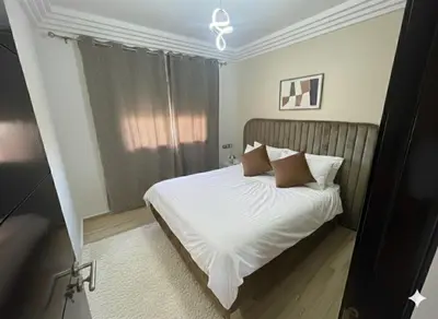 a bedroom with a bed with white sheets and pillows at Appartement vue sur mer - Chill ocean view in Rabat