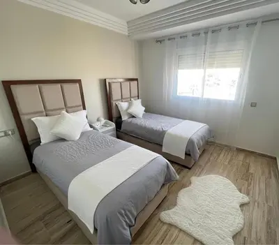 a bedroom with two beds and a window at Appartement vue sur mer - Chill ocean view in Rabat