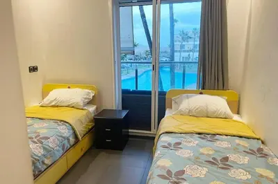 two beds in a room with a view of a pool at Casablanca !Tamaris! 2 bedrooms! Pool & Sea View! in Dar Sidi Slimane