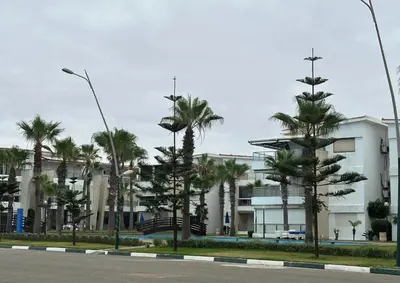 a street with palm trees in front of a building at Casablanca !Tamaris! 2 bedrooms! Pool & Sea View! in Dar Sidi Slimane