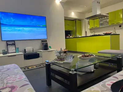 a living room with a table and a large screen at Casablanca !Tamaris! 2 bedrooms! Pool & Sea View! in Dar Sidi Slimane