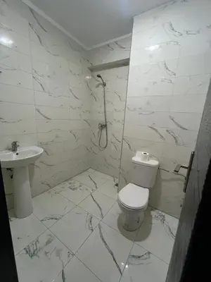a white bathroom with a toilet and a sink at 2 Bedrooms 3 beds and a living room in Dar Bouazza in Dar Ben Abdallah Ben Dehbi